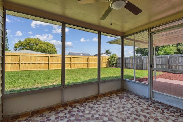 unfurnished sunroom with ceiling fan