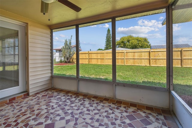 unfurnished sunroom featuring ceiling fan