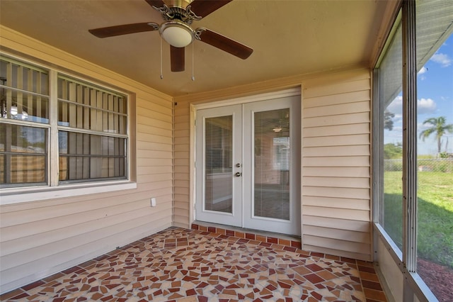 unfurnished sunroom featuring ceiling fan