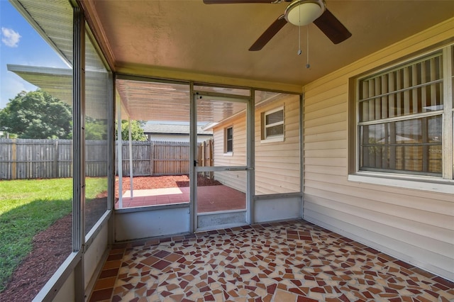 unfurnished sunroom with ceiling fan