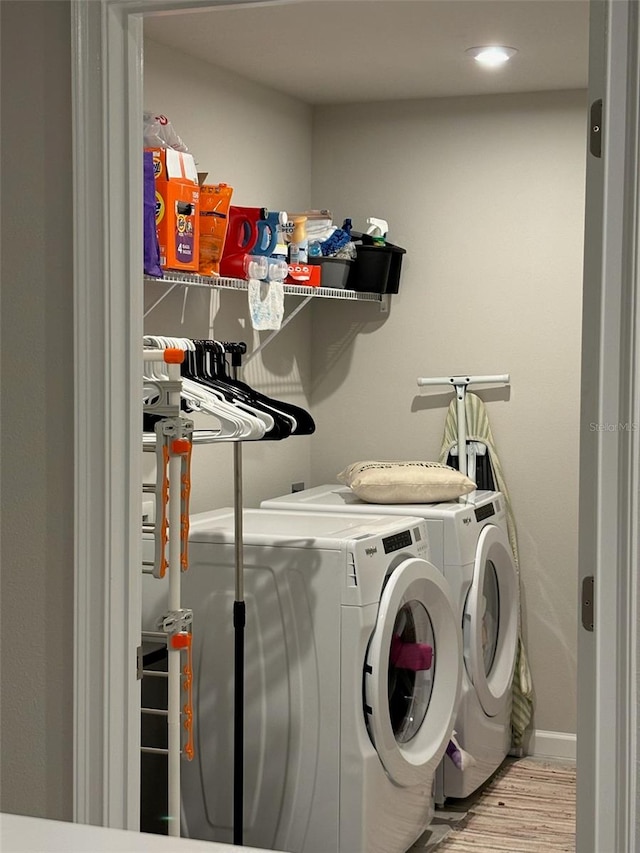 laundry area featuring washer and dryer and light hardwood / wood-style floors