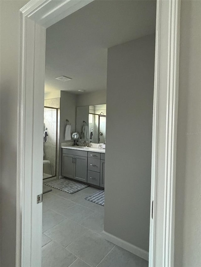 bathroom with vanity, a shower, and tile patterned floors