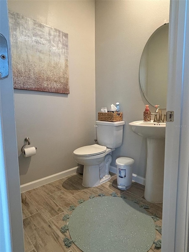 bathroom with hardwood / wood-style flooring and toilet