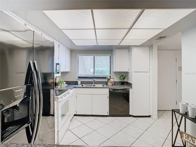 kitchen with black appliances, white cabinets, sink, and light tile patterned floors