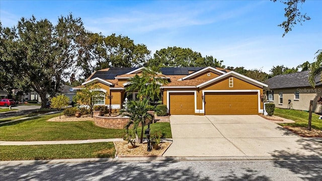 view of front of property featuring a garage, a front lawn, and solar panels