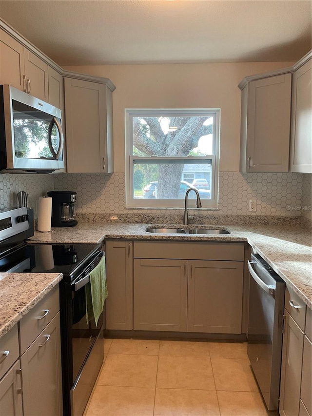 kitchen with stainless steel appliances, sink, and tasteful backsplash