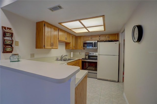 kitchen with sink, light tile patterned flooring, kitchen peninsula, and stainless steel appliances