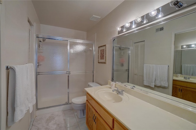 bathroom featuring vanity, toilet, tile patterned floors, and a shower with door