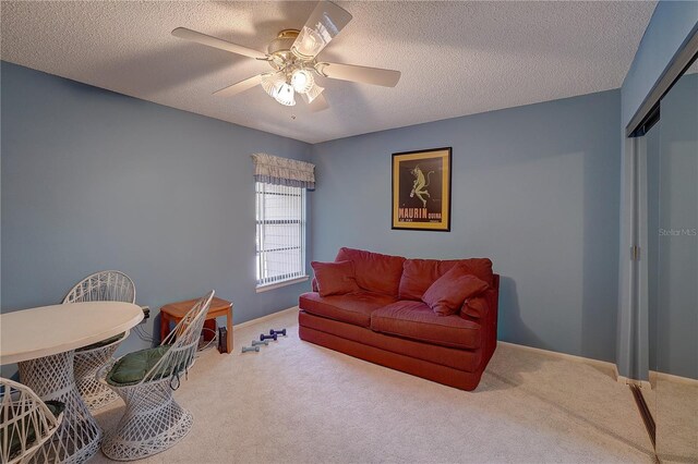 carpeted living room featuring a textured ceiling and ceiling fan