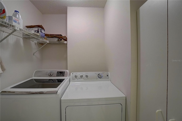 clothes washing area with a textured ceiling and washing machine and clothes dryer