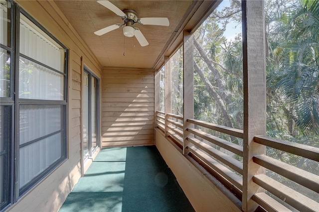 unfurnished sunroom with wood ceiling and ceiling fan