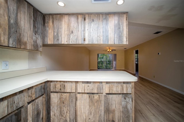 kitchen with light hardwood / wood-style flooring, kitchen peninsula, and ceiling fan