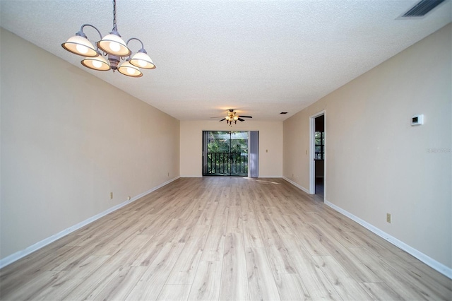 unfurnished room featuring a textured ceiling, light wood-style flooring, ceiling fan with notable chandelier, baseboards, and visible vents