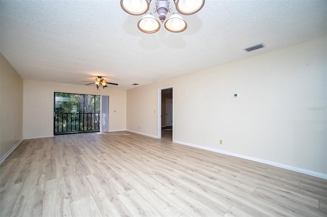 spare room with light hardwood / wood-style floors, a textured ceiling, and ceiling fan with notable chandelier