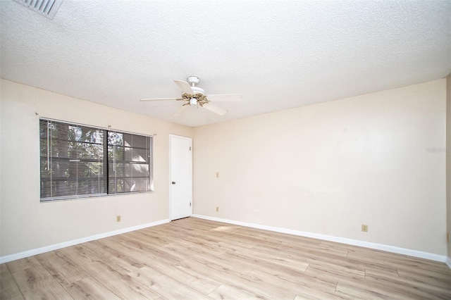 spare room featuring visible vents, baseboards, ceiling fan, a textured ceiling, and light wood finished floors