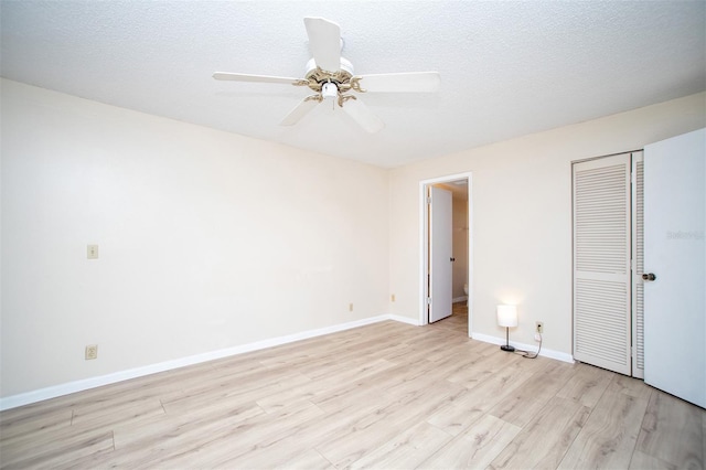 unfurnished bedroom featuring a textured ceiling, a ceiling fan, baseboards, light wood-type flooring, and a closet