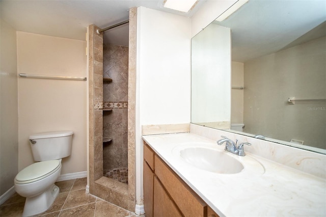 bathroom with toilet, tile patterned flooring, vanity, and tiled shower