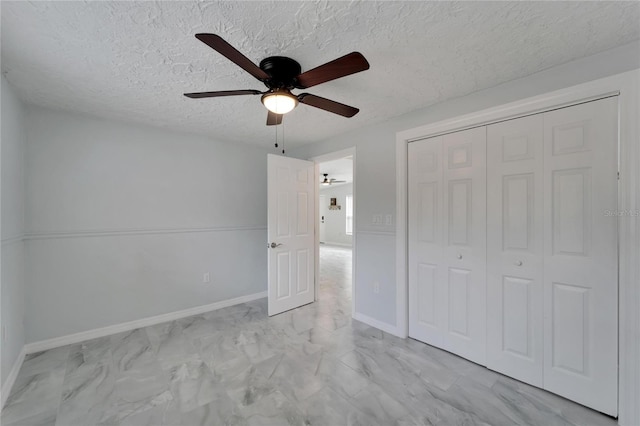 unfurnished bedroom with ceiling fan, a closet, and a textured ceiling