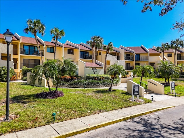 view of front of home with a front yard and a balcony