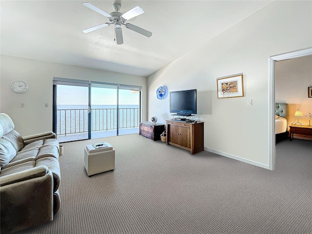 carpeted living area with a ceiling fan and baseboards