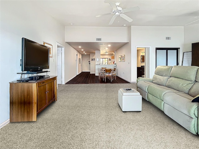 carpeted living room with visible vents, ceiling fan, and baseboards