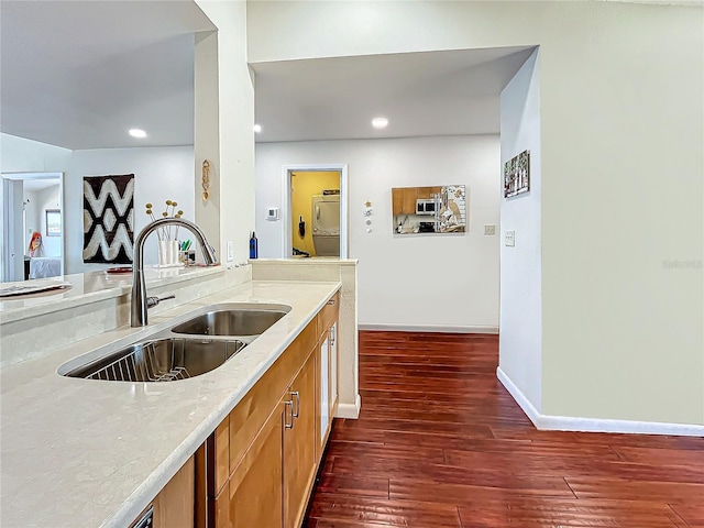 kitchen featuring baseboards, brown cabinetry, dark wood-type flooring, a sink, and recessed lighting