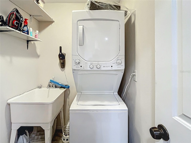 laundry area with stacked washer and clothes dryer, a sink, and laundry area