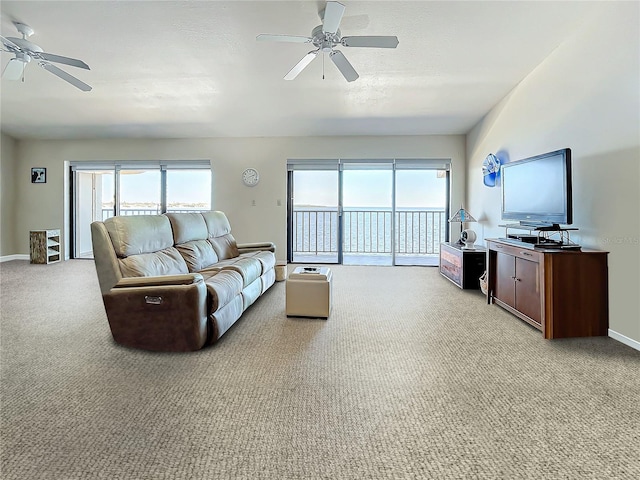 living room with a healthy amount of sunlight, light colored carpet, ceiling fan, and baseboards