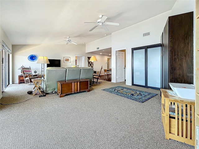 carpeted living area featuring lofted ceiling, visible vents, and a ceiling fan