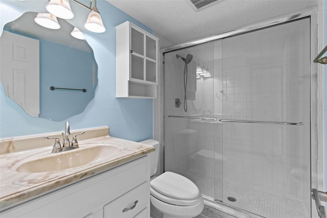 bathroom featuring toilet, an enclosed shower, a textured ceiling, and vanity