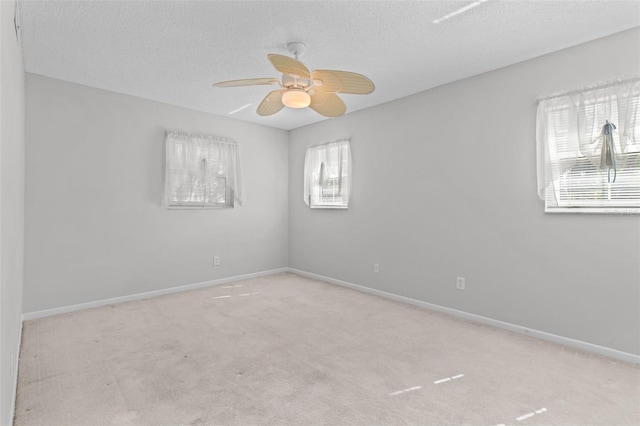 carpeted empty room with a textured ceiling and ceiling fan