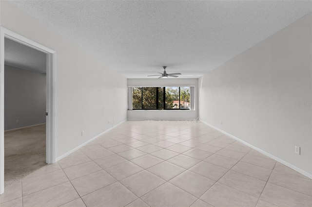 empty room with light tile patterned flooring, a textured ceiling, and ceiling fan