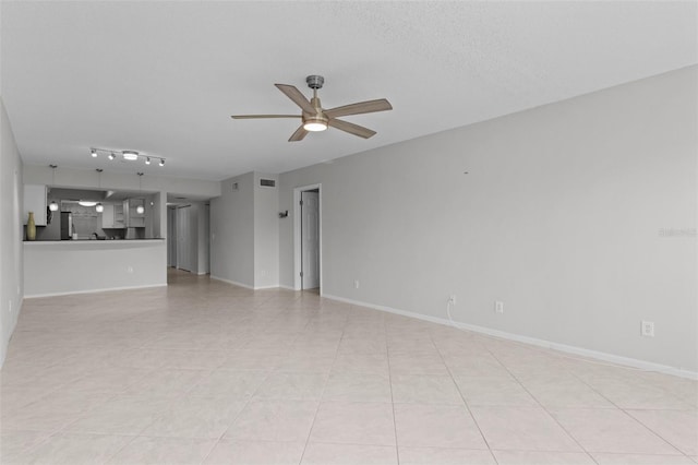 unfurnished living room featuring ceiling fan, a textured ceiling, and light tile patterned floors