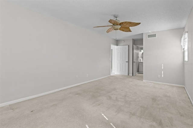 empty room featuring light carpet, a textured ceiling, and ceiling fan