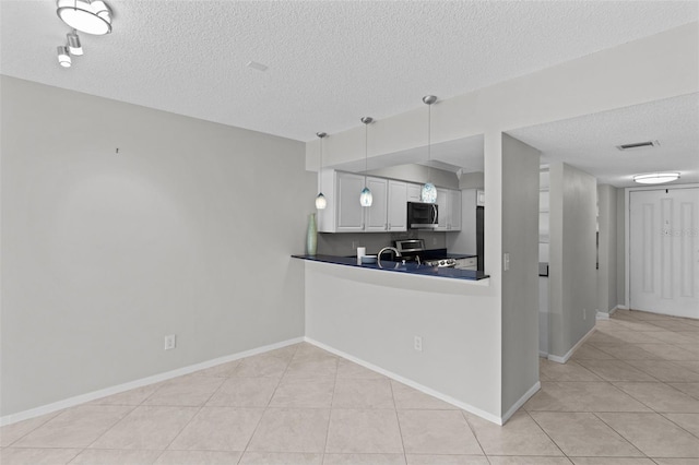 kitchen with a textured ceiling, stainless steel appliances, pendant lighting, white cabinets, and light tile patterned floors