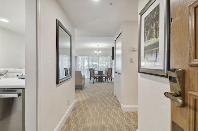 hall featuring a chandelier and light colored carpet