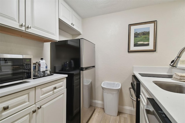 36750 US Highway 19 N Unit 09110, Palm Harbor, FL 34684 - kitchen featuring appliances with stainless steel finishes, light wood-type flooring, light countertops, a toaster, and white cabinetry