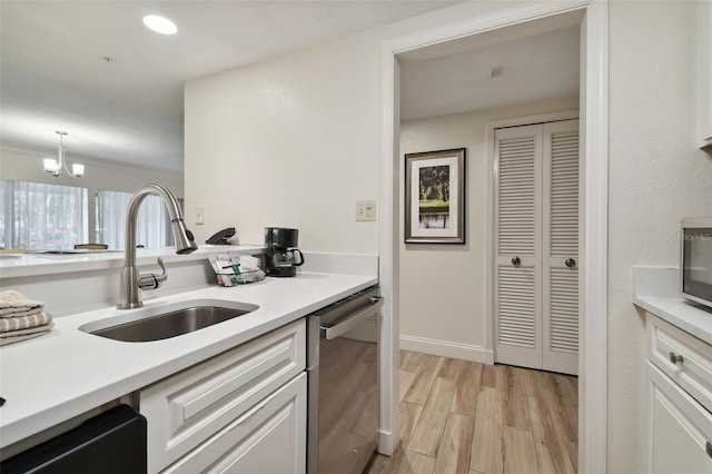 kitchen with white cabinetry, a chandelier, light wood-type flooring, dishwasher, and sink