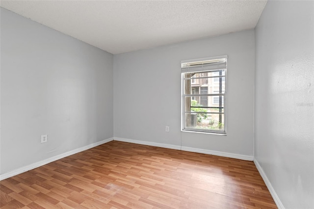 14323 Hanging Moss Cir Unit 102, Tampa, FL 33613 - unfurnished room with a textured ceiling, light wood-style floors, and baseboards