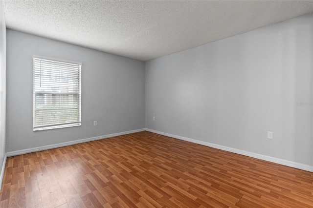 14323 Hanging Moss Cir Unit 102, Tampa, FL 33613 - spare room featuring a textured ceiling, wood finished floors, and baseboards