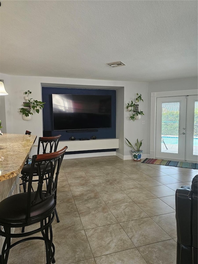 tiled dining space with a textured ceiling