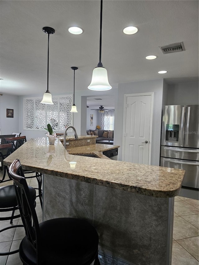 kitchen featuring stainless steel fridge, sink, ceiling fan, and pendant lighting