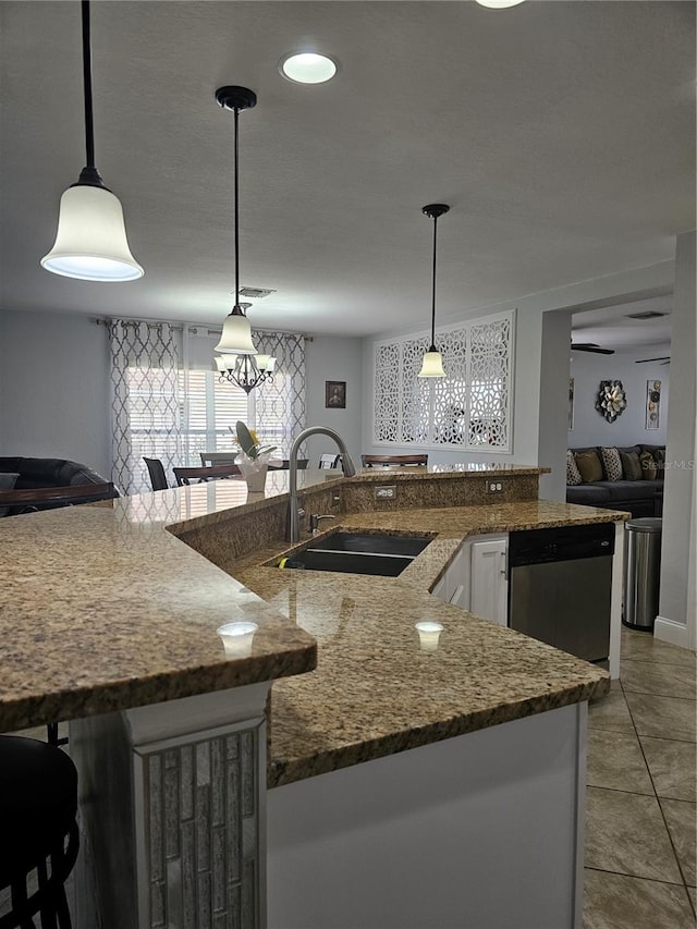 kitchen with stainless steel dishwasher, decorative light fixtures, white cabinets, and sink