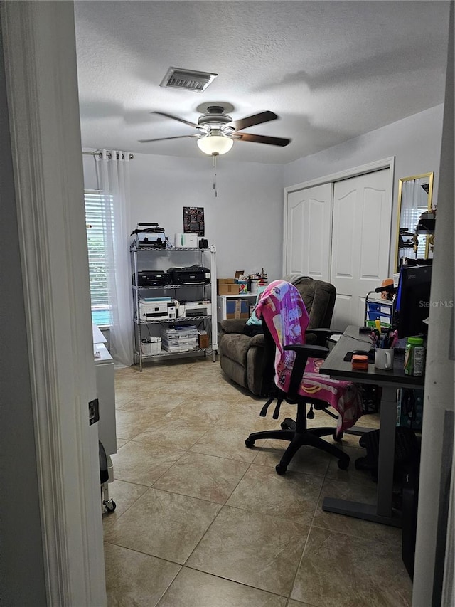 office featuring tile patterned floors, ceiling fan, and a textured ceiling