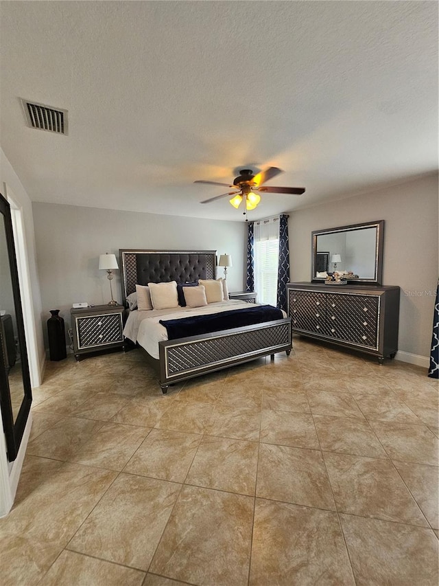 bedroom with ceiling fan and a textured ceiling