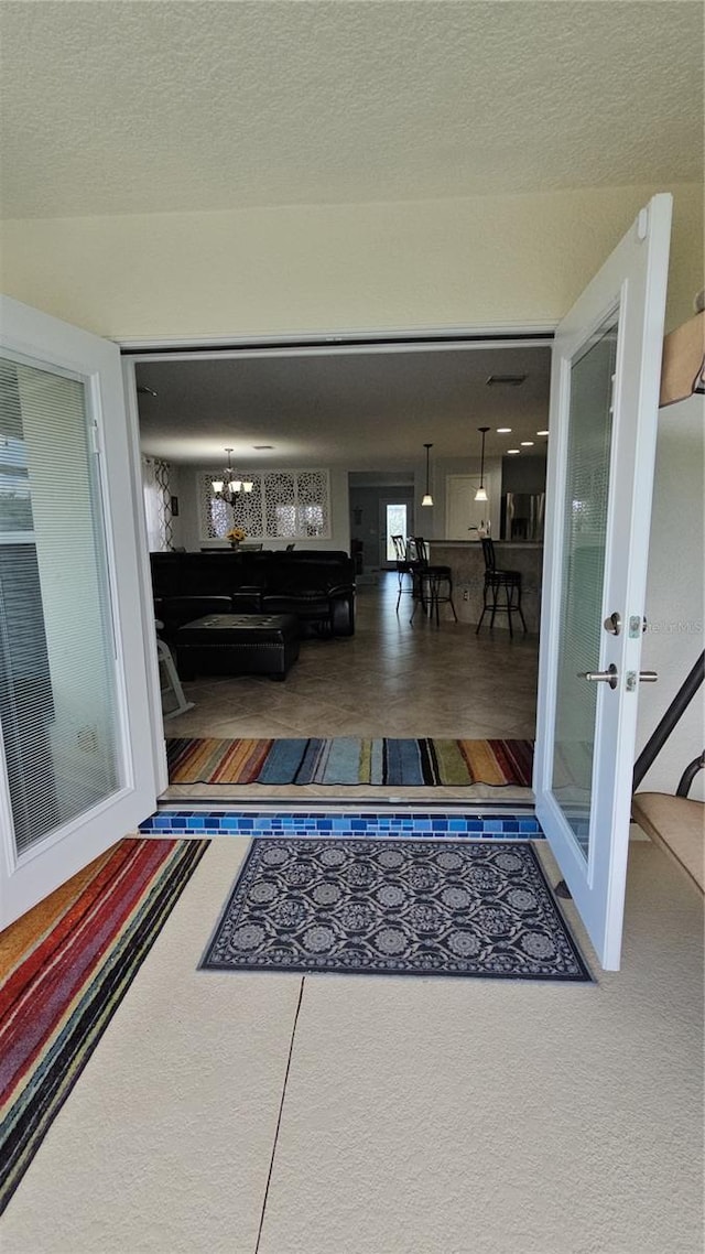 interior space with carpet, a textured ceiling, and french doors