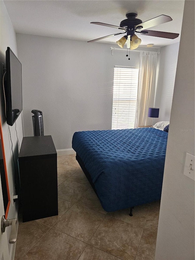 tiled bedroom with ceiling fan