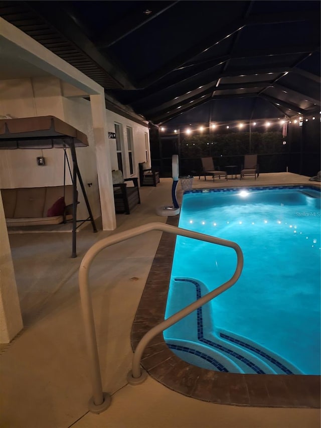 view of pool with a patio and glass enclosure