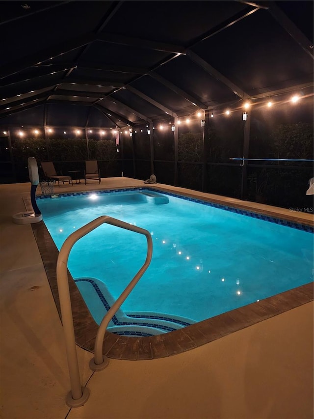 view of swimming pool with a patio area and a lanai