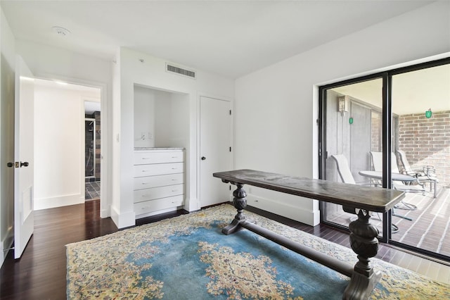 home office with baseboards, visible vents, and wood finished floors